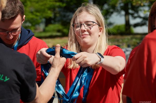 Volunteer händigt Akkreditierungskarten aus bei den Special Olympics Niedersachsen Landesspielen 2023 in Braunschweig