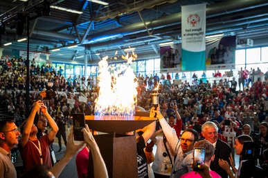 Eröffnungsfeier Landesspiele Münster 2024. Viele Zuschauer. In Vordergrund Feuerschale. Feuer wurde gerade entfacht.