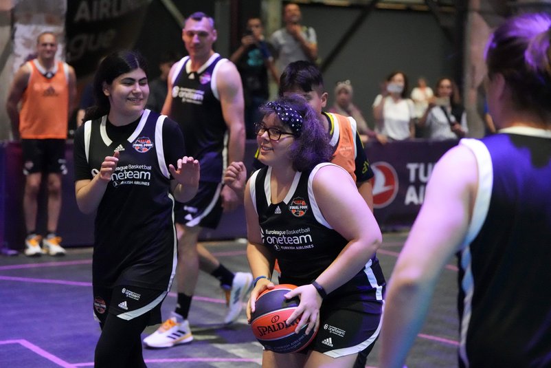 Basketballspielerinnen bei der One Team Session. Die Spielerin rechts hält den Ball in der Hand. Beide tragen schwarze Basketballtrikots.